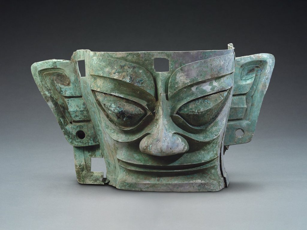 Máscaras de bronze, Esculturas complexas, Relíquias culturais, Civilização chinesa antiga, Descobertas arqueológicas, Reino Shu, Exposição em Hong Kong, Avançada metalurgia do bronze, Artefatos antropomórficos de bronze, Técnicas de fundição em peça, Cultura material de Sanxingdui, Origem e desenvolvimento arqueológico, Mistérios e segredos de Sanxingdui, Influências estrangeiras e extraterrestres, Narrativas artísticas da história humana, Civilizações antigas e sua existência, Curiosidade sobre a cultura de Sanxingdui, Exploração dos mistérios da humanidade.